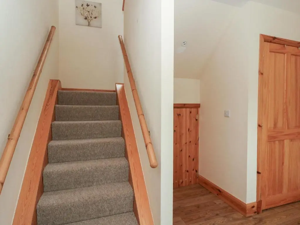 a staircase in a house with a wooden door at Taffs Barn in Fortrose