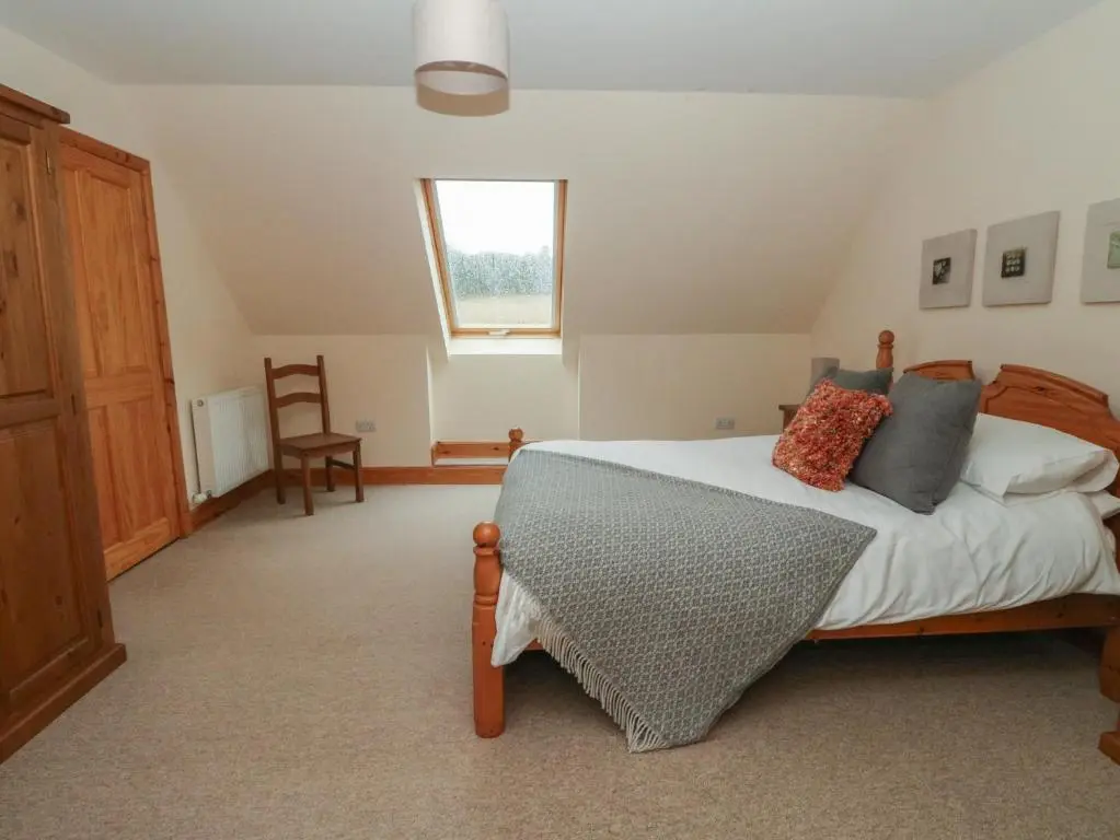 a bedroom with a bed and a window at Taffs Barn in Fortrose