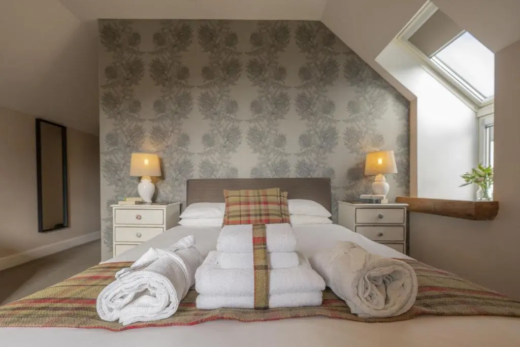 a bedroom with a bed with towels on it at Craggan Mill in Grantown on Spey