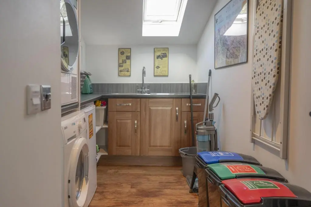 a kitchen with a sink and a washing machine at Craggan Mill in Grantown on Spey