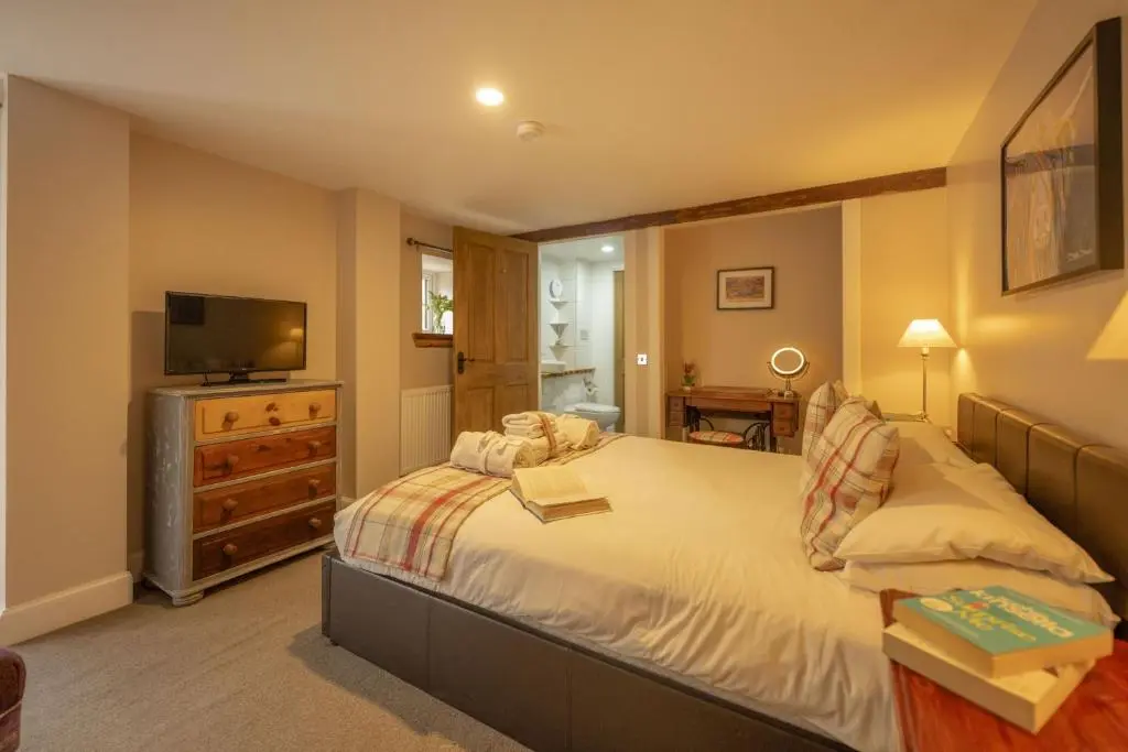 a bedroom with a large bed and a television at Craggan Mill in Grantown on Spey