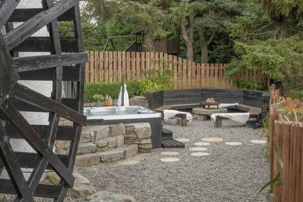 a backyard with a tub and a fire pit at Craggan Mill in Grantown on Spey
