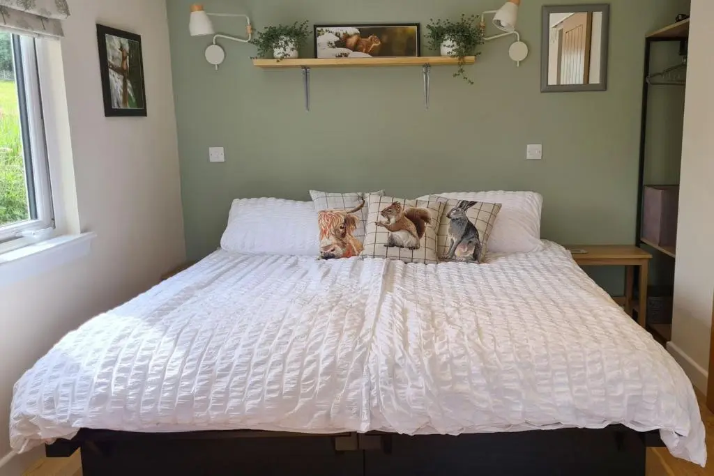 a bed with a white comforter in a bedroom at The Drey Inchberry