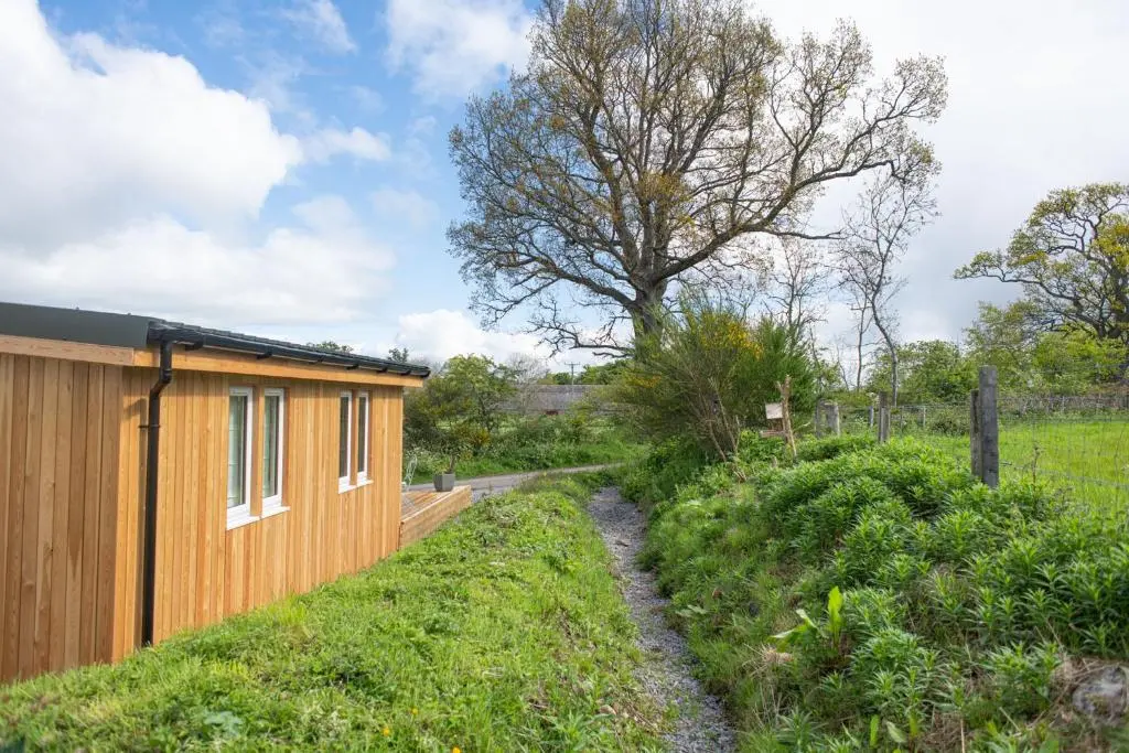 a house with a wooden fence next to a field at The Drey Inchberry