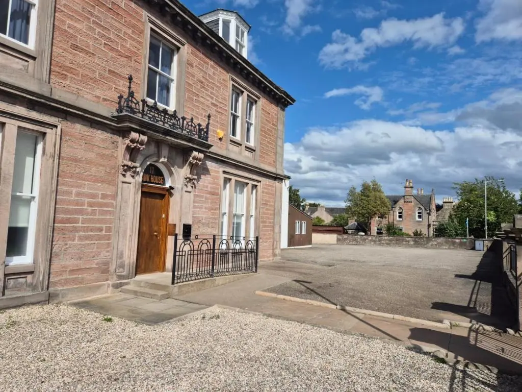 a brick building with a gate in front of it at Bank House in Inverness