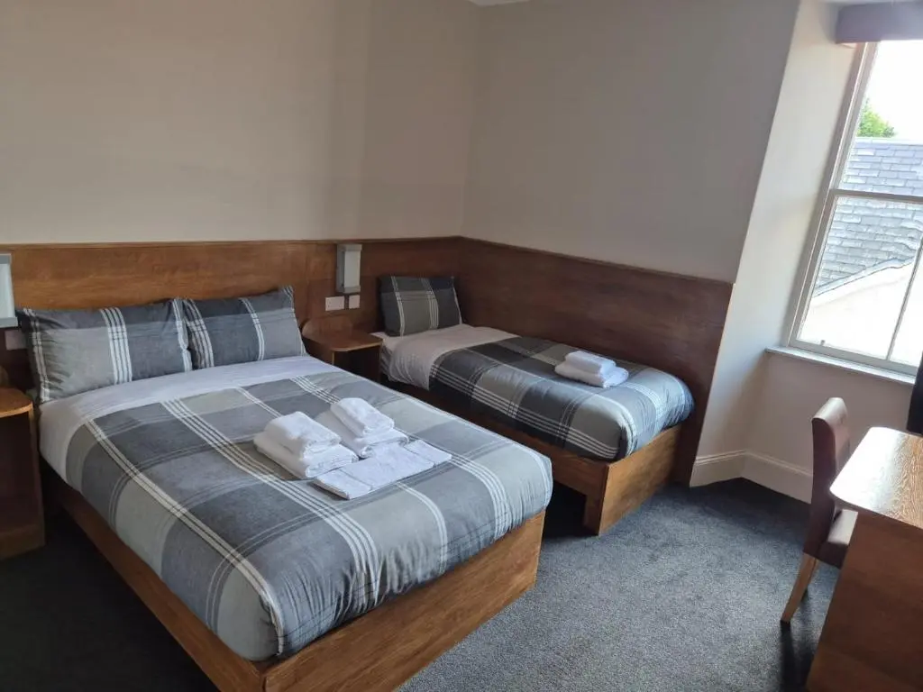 a bedroom with two beds and a window at Bank House in Inverness