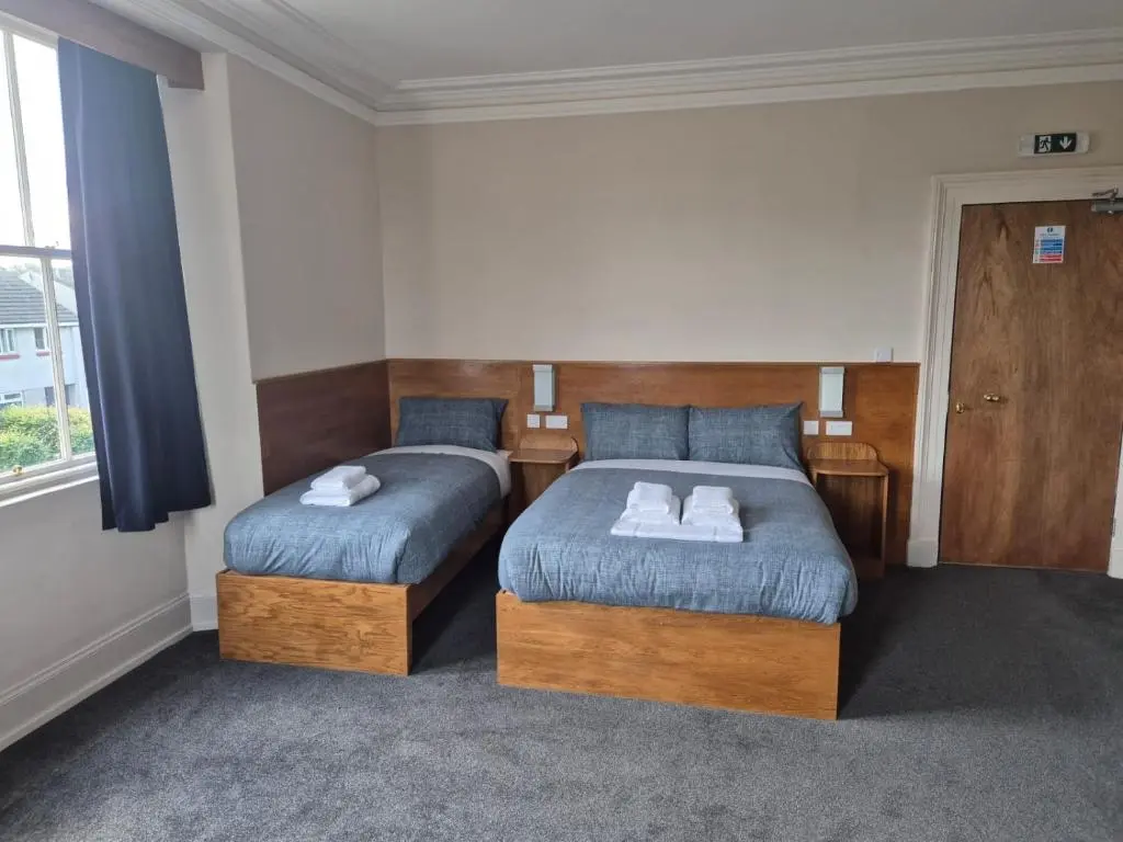 a bedroom with two beds and a window at Bank House in Inverness