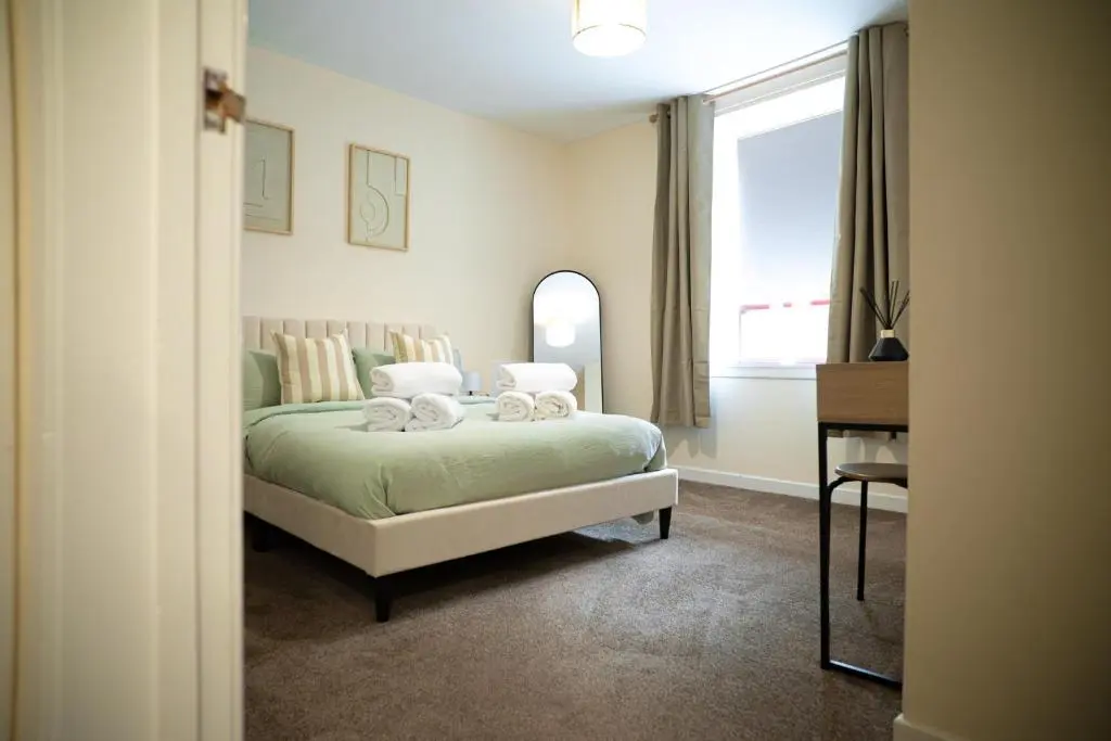 a bedroom with a bed and a window and a desk at Innes Street Apartment in Inverness