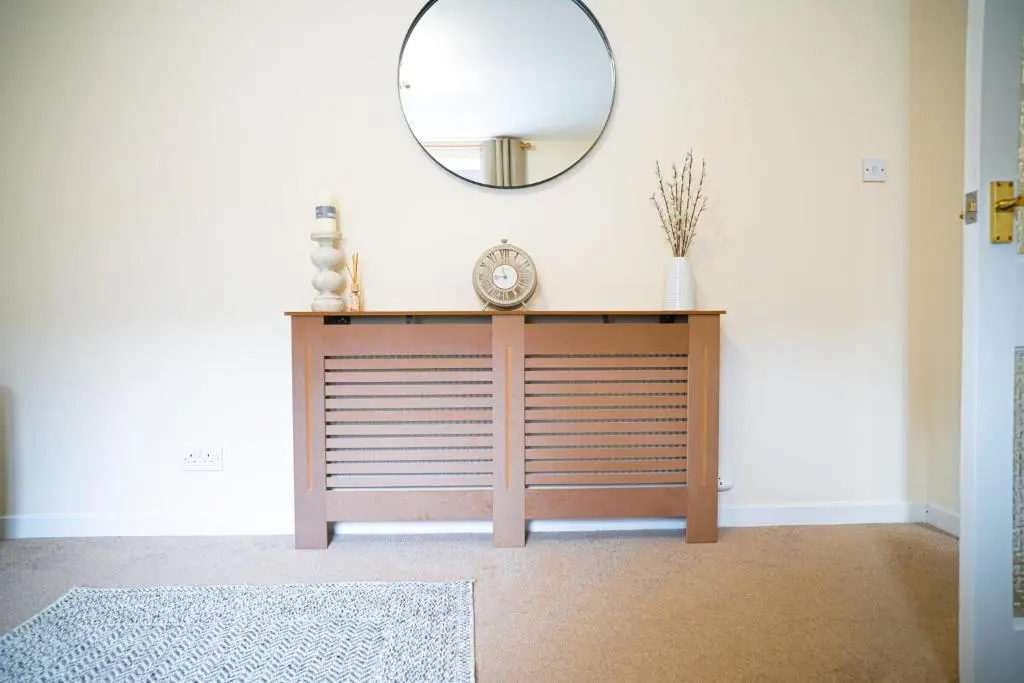 a dressing table with a mirror and a clock on it at Innes Street Apartment in Inverness