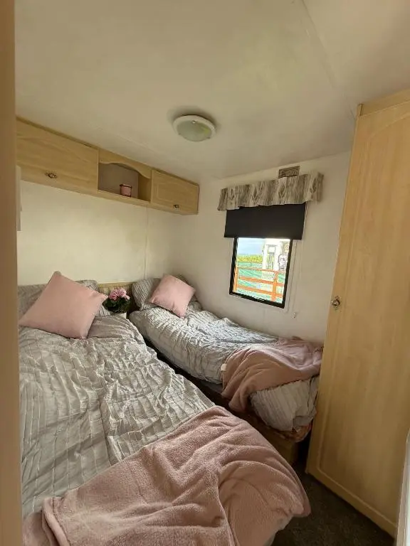 a room with three beds in a small room at Caravan in Banff