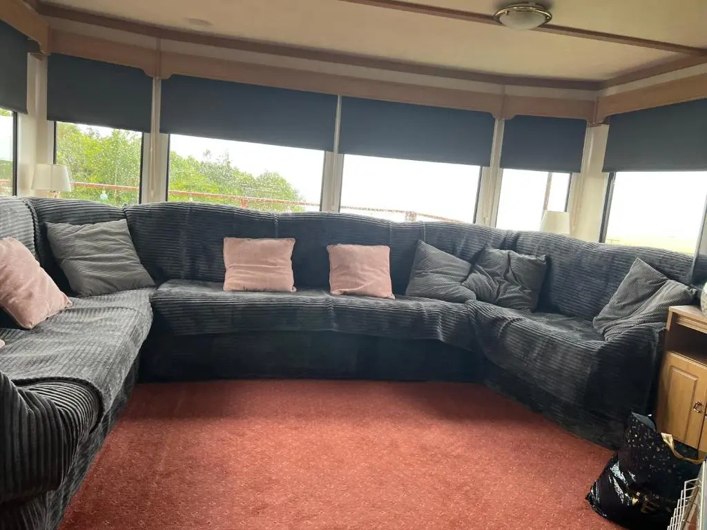 a large blue couch in a living room with pillows at Caravan in Banff