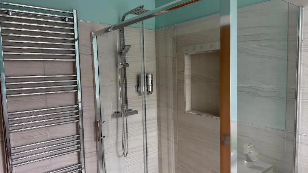 a shower with a glass door in a bathroom at The Bakehouse - by Caithness Luxury Apartments NC500 - 5 Bedroom Luxury Holiday Home - Sleeps Work teams upto 5 & holiday makers upto 10 in Wick