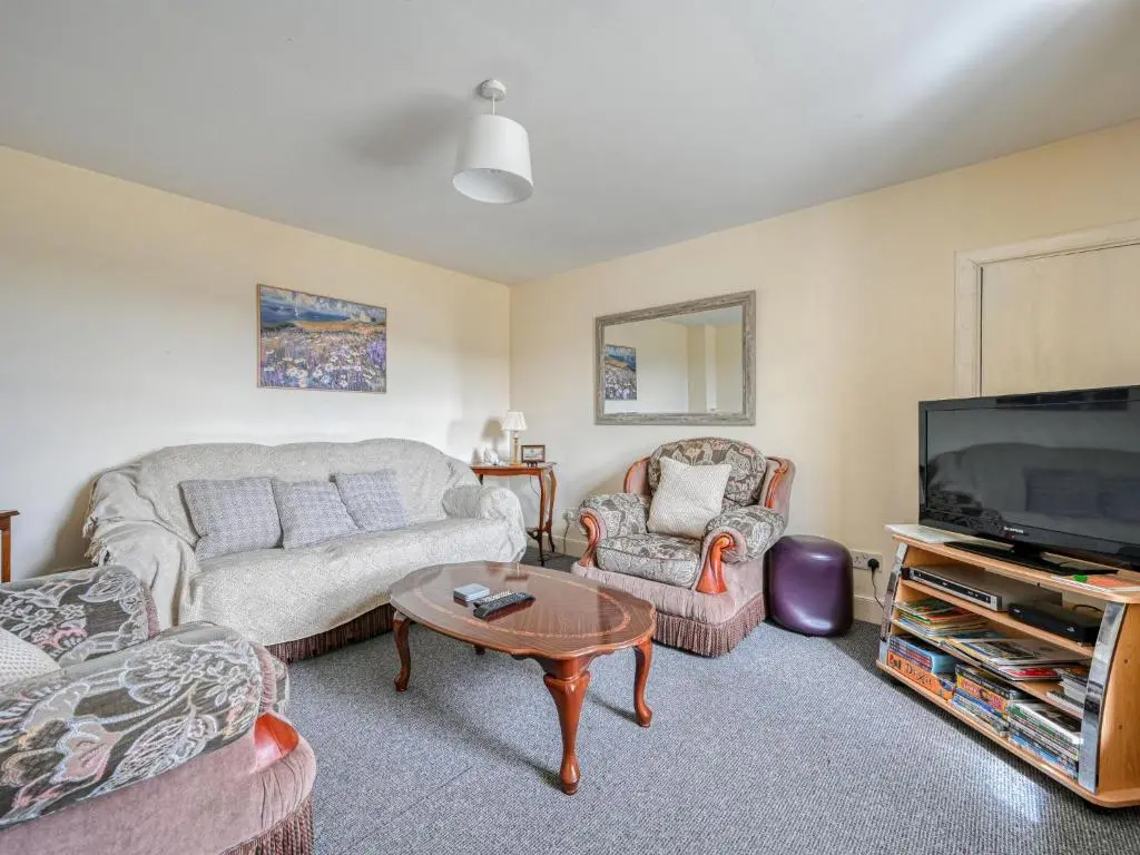 a living room with a couch and a tv at Holiday Home The Manor House by Interhome in Balnain