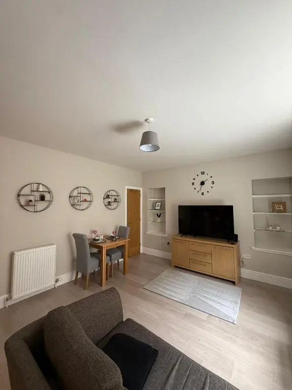a living room with a couch and a tv and a table at The Willows in Nairn