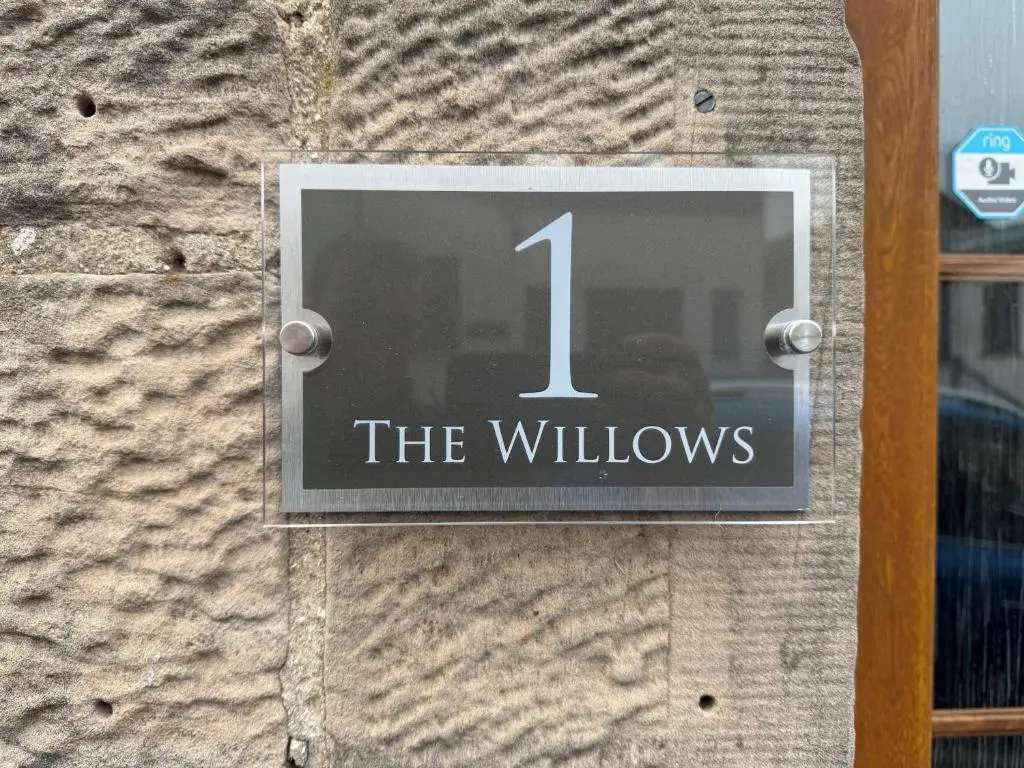 a sign on a building that reads the willows at The Willows in Nairn