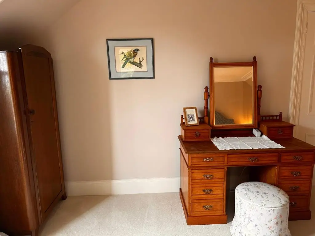a bathroom with a wooden dresser with a mirror at Clashmore House in Dornoch