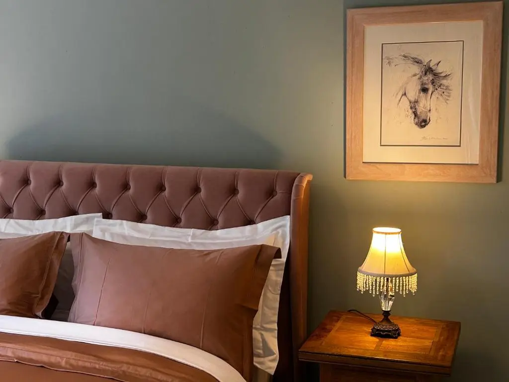 a bedroom with a bed with a lamp on a table at Clashmore House in Dornoch