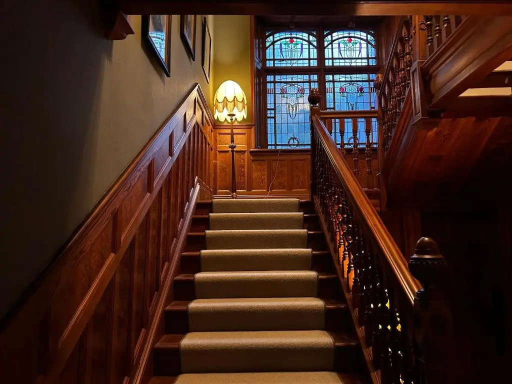 a staircase in a building with a stained glass window at Clashmore House in Dornoch