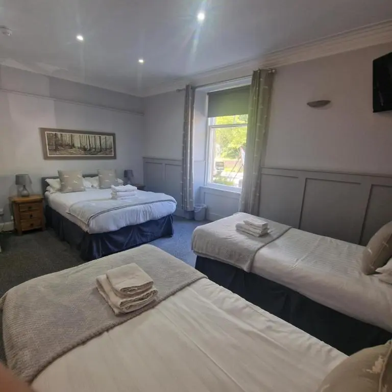 a hotel room with two beds and a window at Black Isle Holiday Apartments Avoch in Avoch