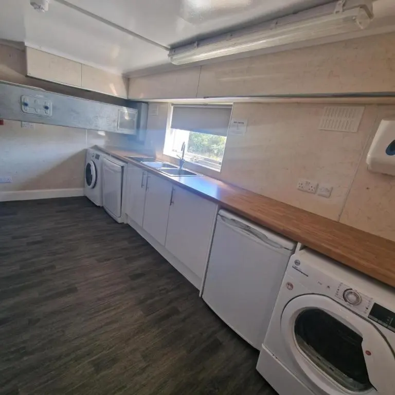 a kitchen with a sink and a washing machine at Black Isle Holiday Apartments Avoch in Avoch