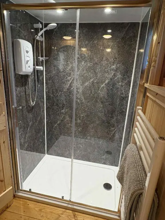 a shower with a glass door in a bathroom at Shepherd's Bothy, Bothan a Bhuachaille, Black Isle in Munlochy