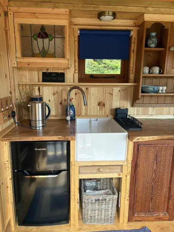 a kitchen with a sink and a stove and a microwave at Shepherd's Bothy, Bothan a Bhuachaille, Black Isle in Munlochy