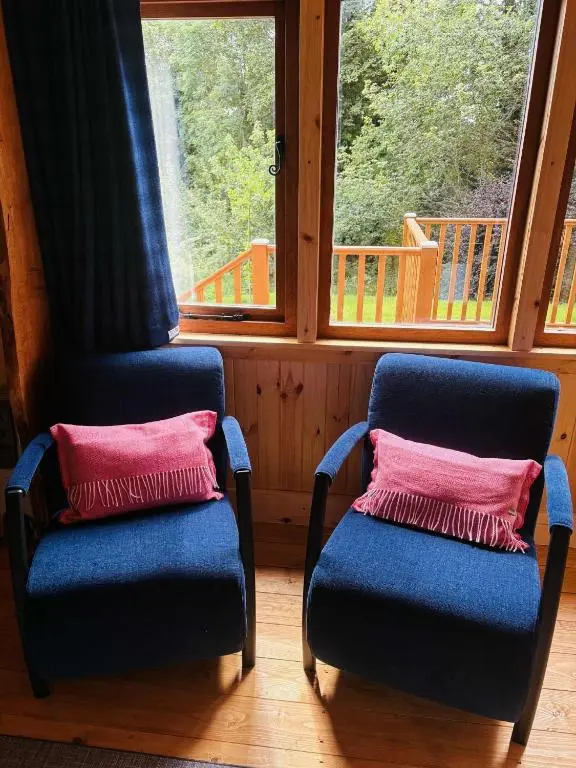two blue chairs with pink pillows in front of a window at Shepherd's Bothy, Bothan a Bhuachaille, Black Isle in Munlochy