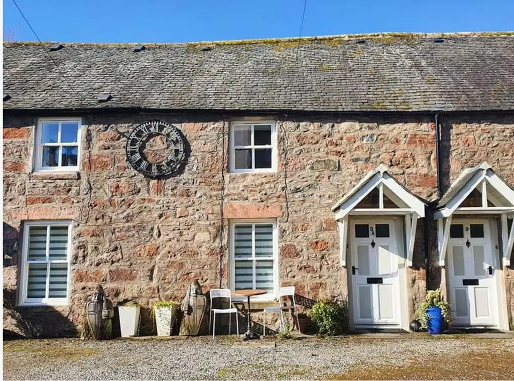 a brick building with a clock on the side of it at 1 Bedroom Alexander Cottage-Free Parking in Inverness