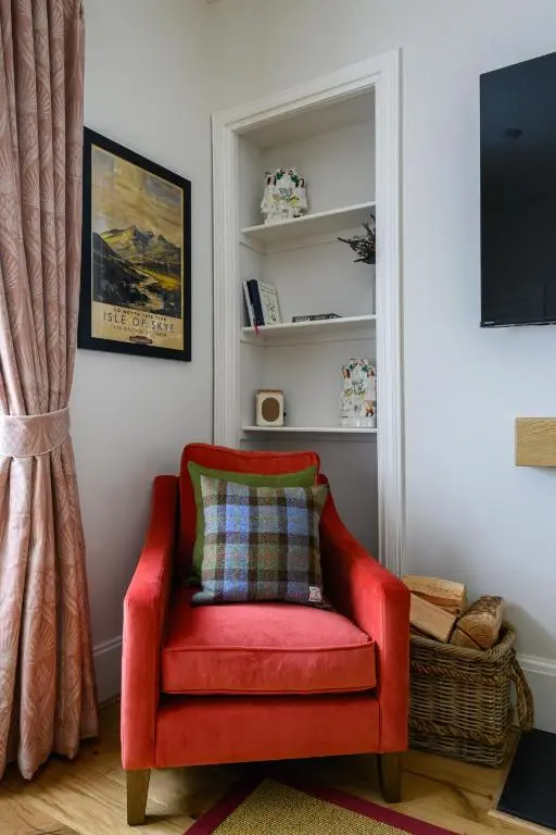 a red chair with a pillow in a room at Harris House in Inverness