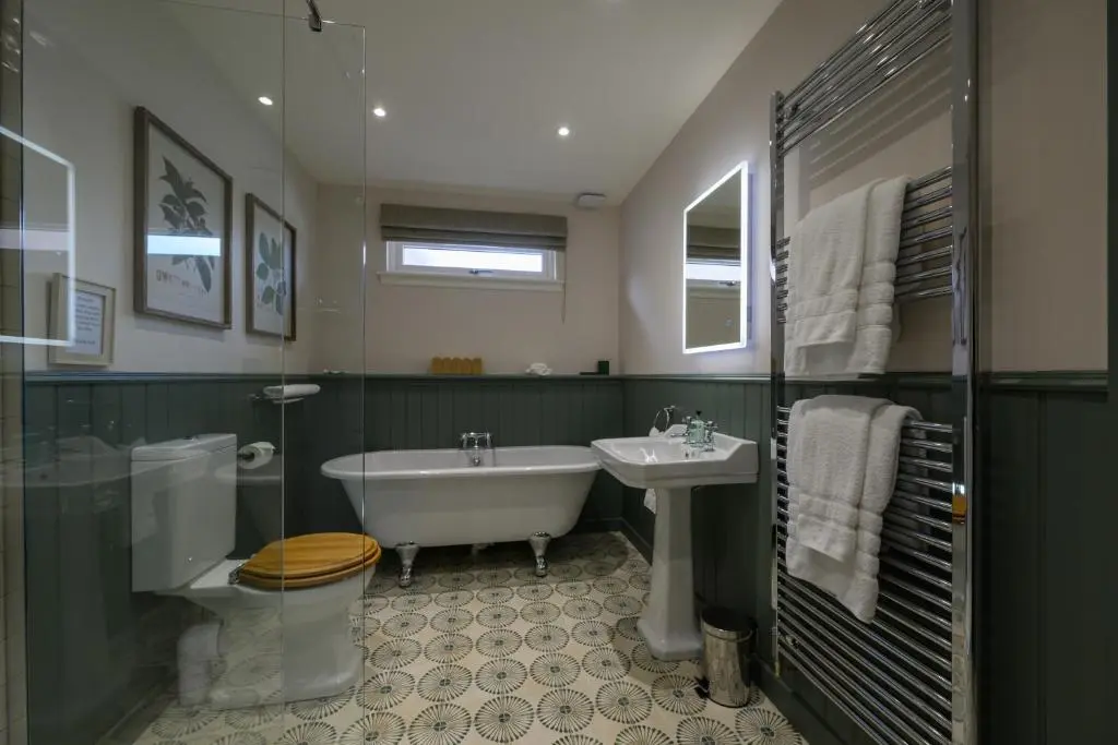a bathroom with a tub and a toilet and a sink at Harris House in Inverness