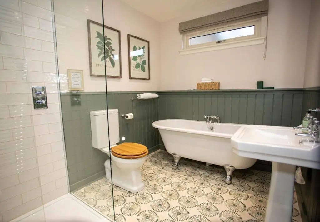 a bathroom with a tub and a toilet and a sink at Harris House in Inverness