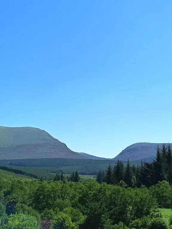a view of hills and trees with mountains in the background at River Black Water inn in Garve