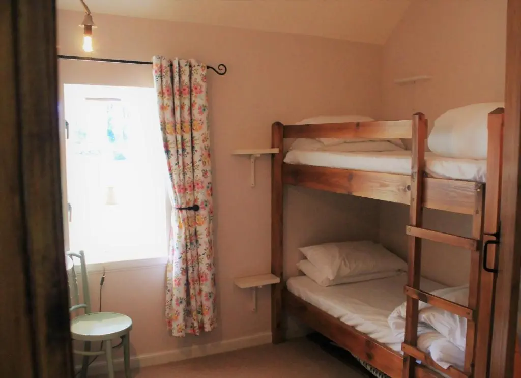 a room with two bunk beds and a window at St Brandon House Country Cottages in Boyndie