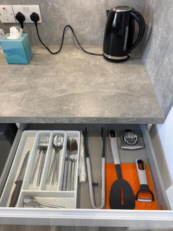 a drawer filled with utensils on a counter at Altons Bothy Guest House