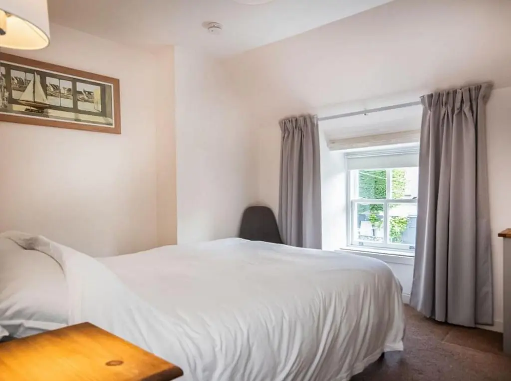 a bedroom with a white bed and a window at 1 Bedroom Alexander Courtyard-Free Parking in Inverness