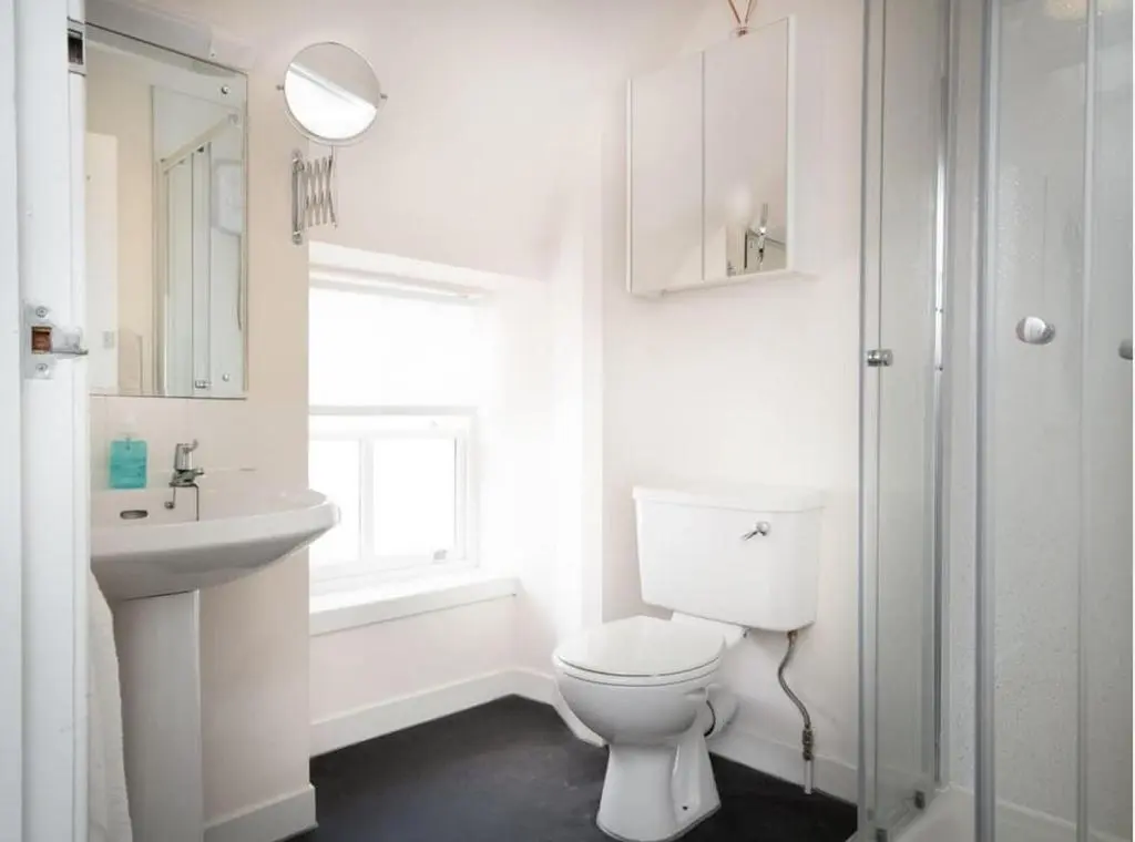 a white bathroom with a toilet and a sink at 1 Bedroom Alexander Courtyard-Free Parking in Inverness