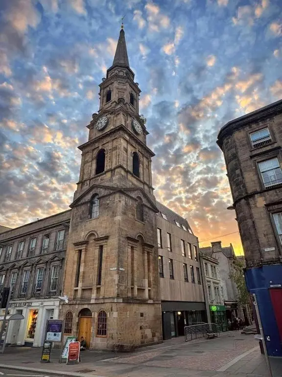 an old building with a tower with a clock on it at V\u016b by the Bridge, Inverness City Centre in Inverness
