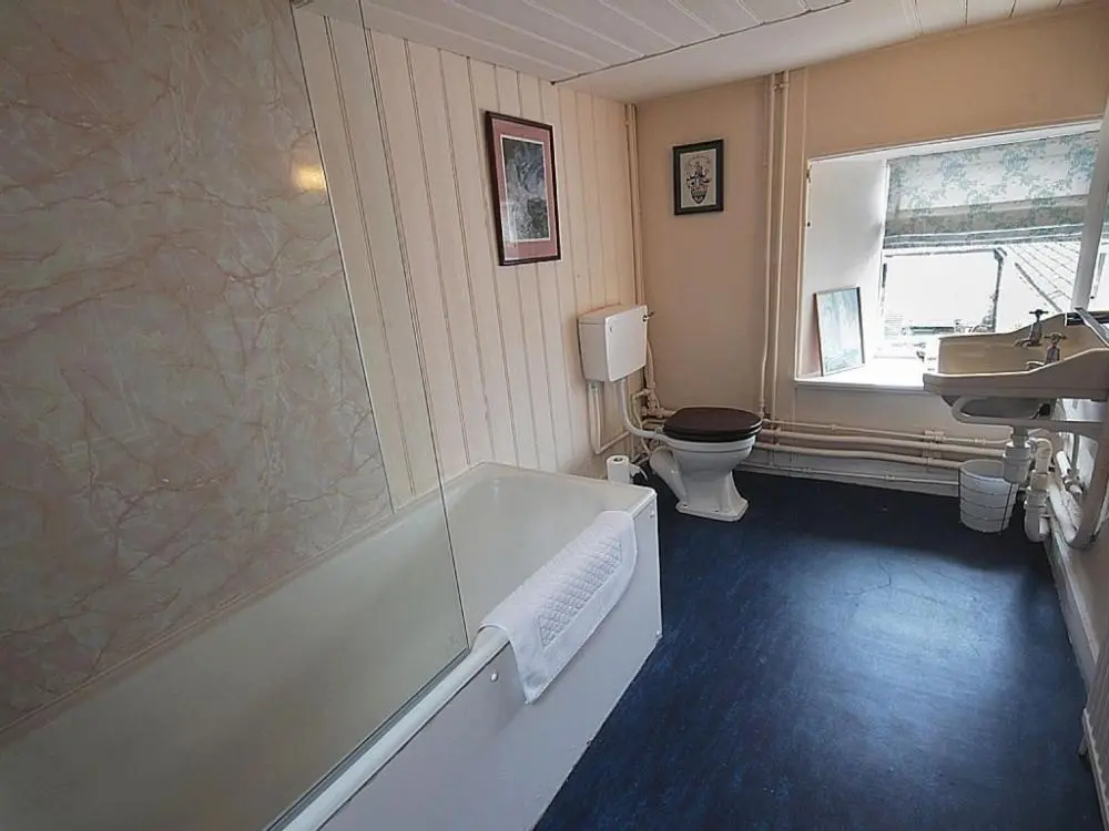 a bathroom with a tub and a toilet and a sink at Biallid House in Newtonmore