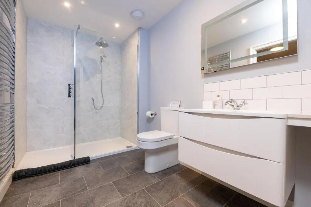 a bathroom with a shower and a toilet and a sink at Glenview in Tomatin