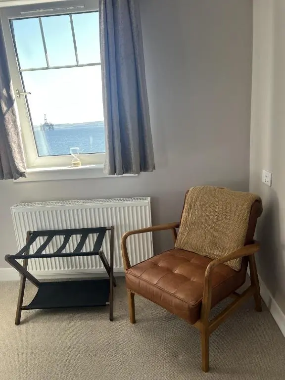 a chair sitting in a room with a window at Tuckers Inn in Invergordon
