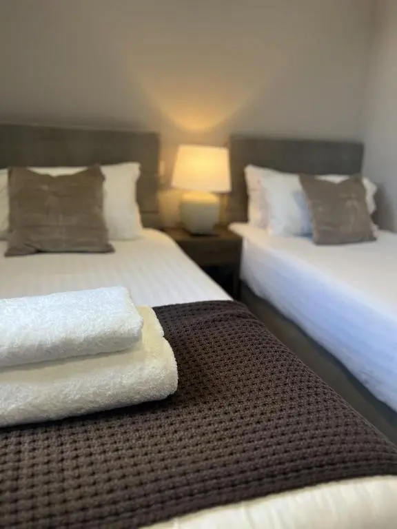 a bedroom with two beds with towels on the bed at Tuckers Inn in Invergordon