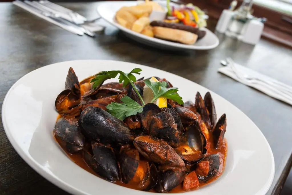 a plate of food with mussels on a table at Tuckers Inn in Invergordon
