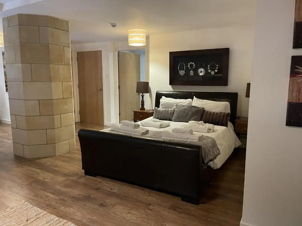 a bedroom with a large bed with white sheets at Romantic getaway at St Andrew's Chapel in Fort Augustus