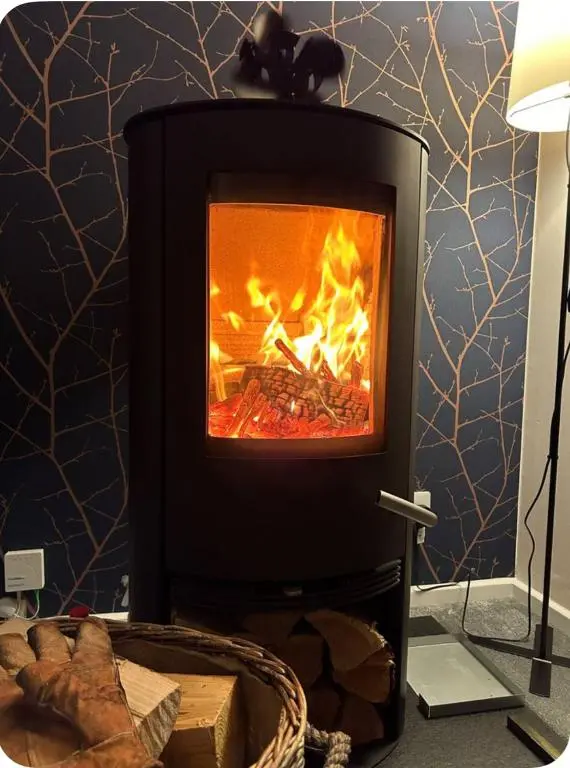 a fireplace with a fire inside of it at 6 Carn Dearg House in Aviemore