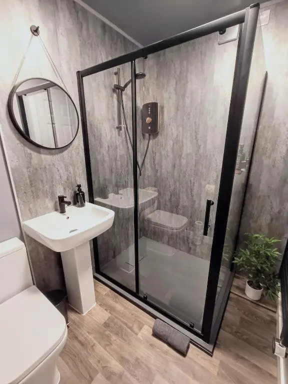 a bathroom with a shower and a sink and a mirror at Central City Apartment - Inverness centre in Inverness