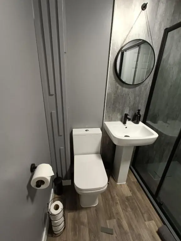 a bathroom with a toilet and a sink and a mirror at Central City Apartment - Inverness centre in Inverness