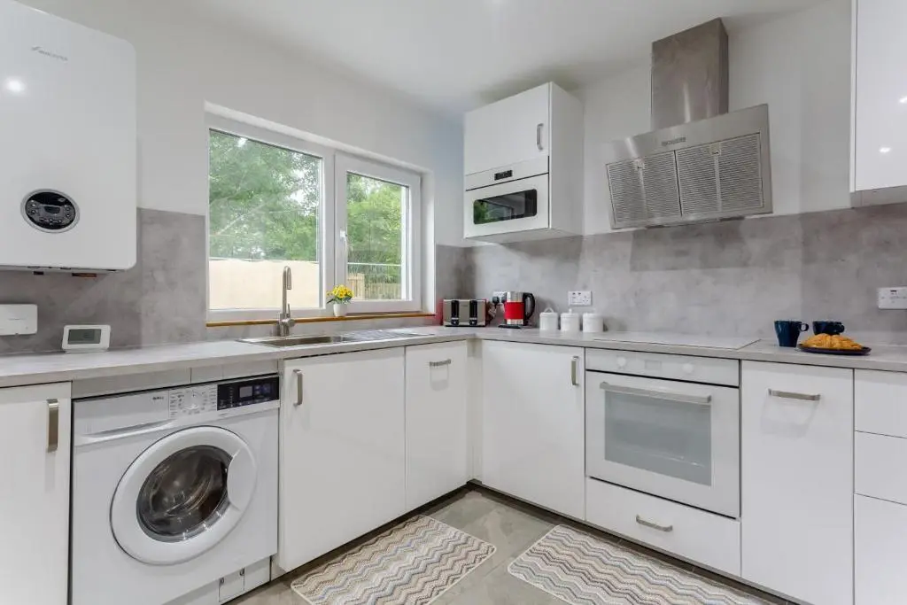 a kitchen with white cabinets and a washer and dryer at 2 Bed in Inverness oc-b32706 in Inverness