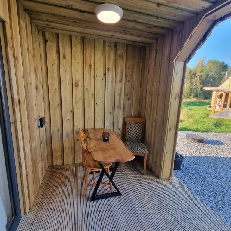 a wooden table and chair in a wooden cabin at Temuka Lodge in Glenurguhart