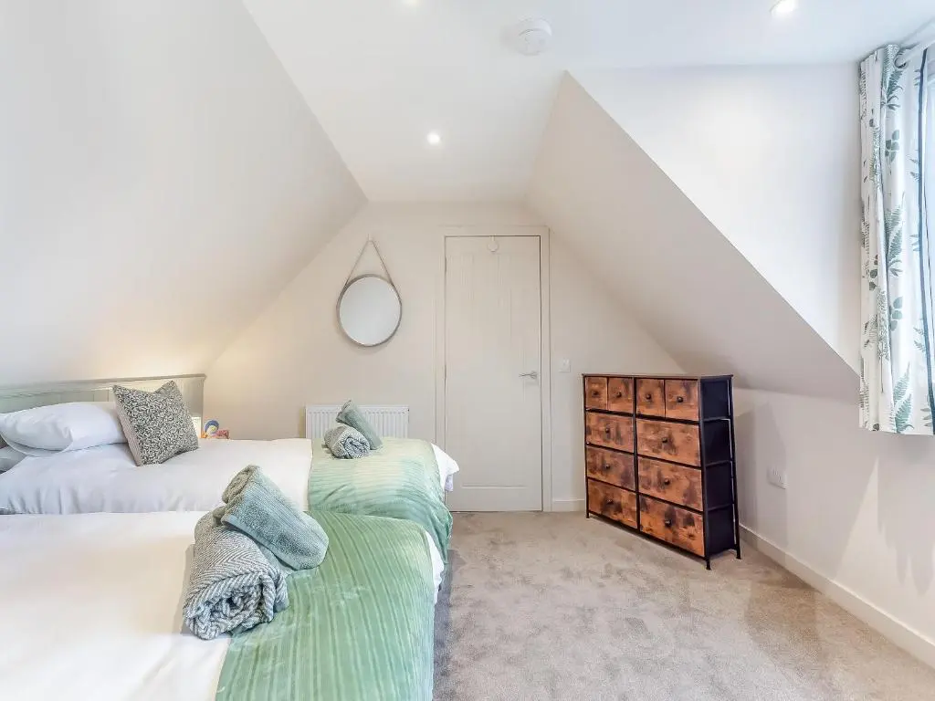 a attic bedroom with two beds and a dresser at Sea Breezes in Balintore