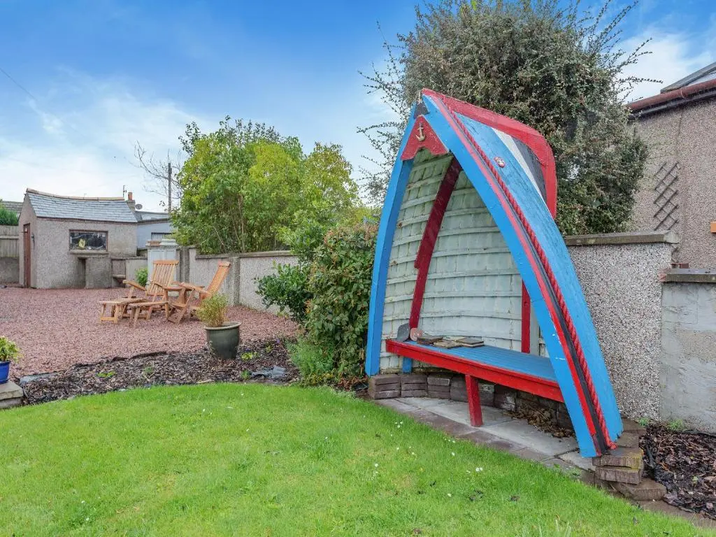a blue and red bench in a yard at Sea Breezes in Balintore